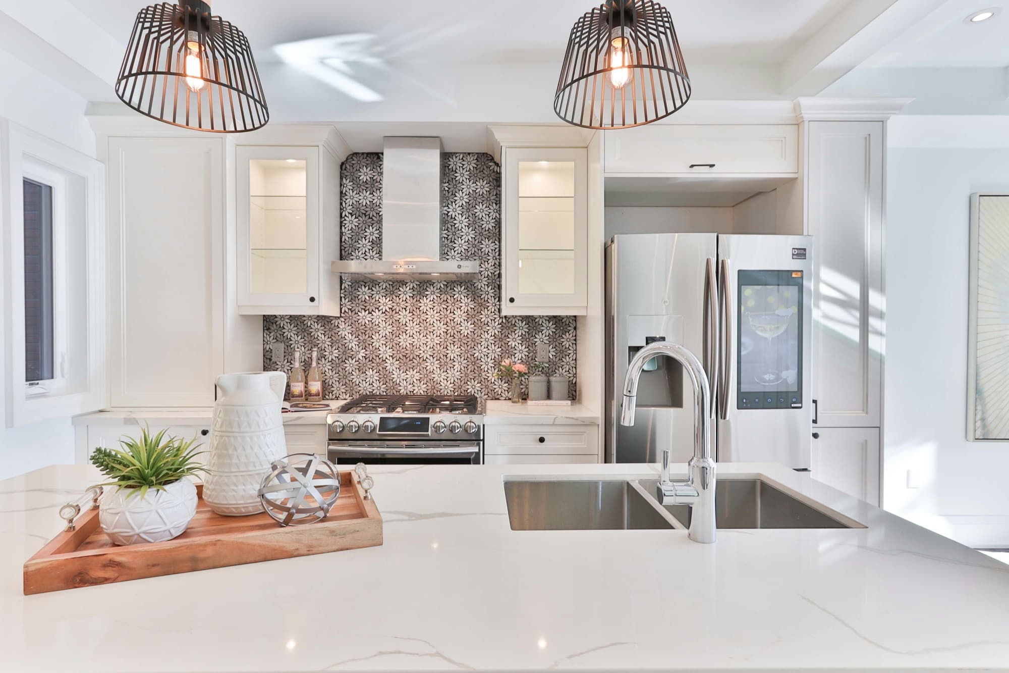 Bright white kitchen with a polished marble island and patterned backsplash